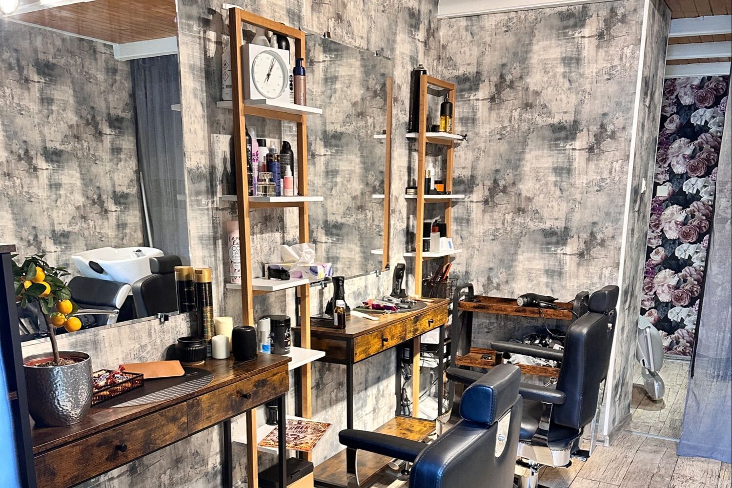 Wnętrze barbershopu KLEON z fotelami barberskimi i betonową ścianą